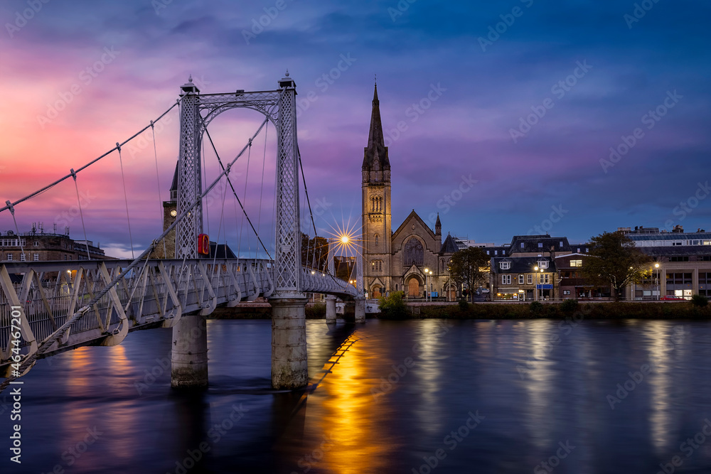 Obraz premium Beautiful, illuminated cityscape of Inverness with Greig Street Bridge and River Ness during sunset, Scotland