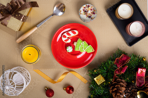 A Christmas dinning table setting with surgar biscuits on a  bright red ceramic plate. photo