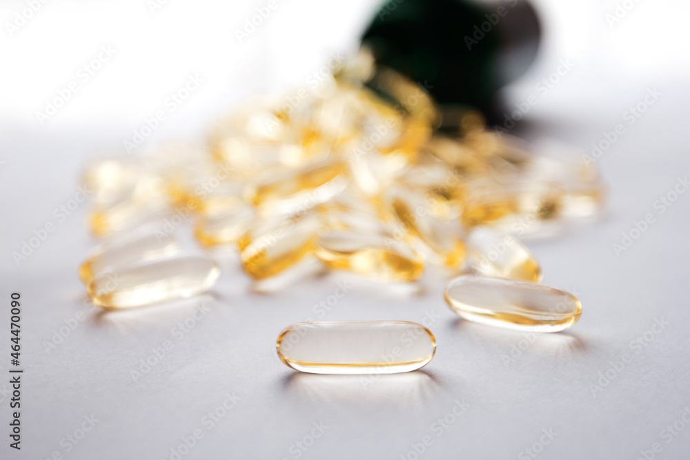 fish oil capsules spilled from the bottle isolated on a white background fish oil capsules spilled from the bottle isolated on a white background