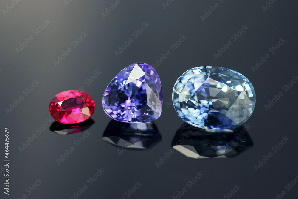 Fototapeta premium Natural corundum gemstones set. Winza unheated red ruby, Tanzanian purple sapphire, Ceylon light blue color sapphire faceted gemstone for making jewelry. Clean rare precious gems settings. Gemology.