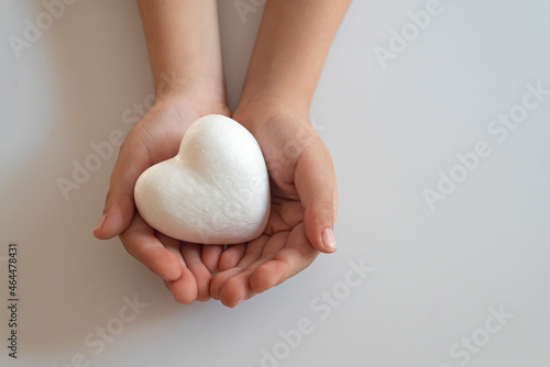boy holding white heart in palm. Organ donation and insurance concept. World heart health concept. World organ donation day. Concept of healthy heart for healthy life. selective focus photo