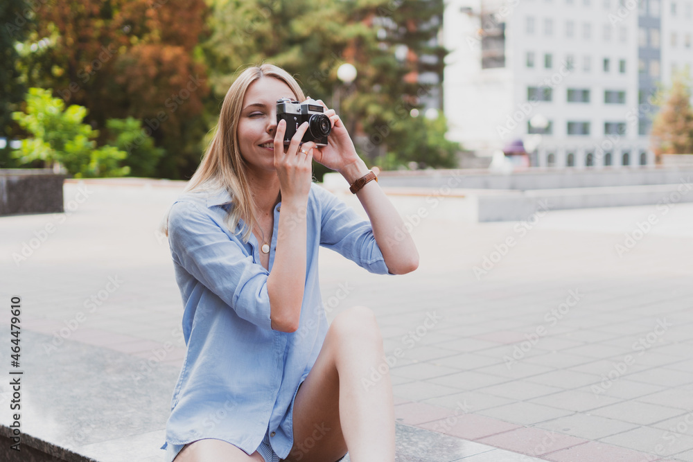 portrait of young charming woman holding retro camera