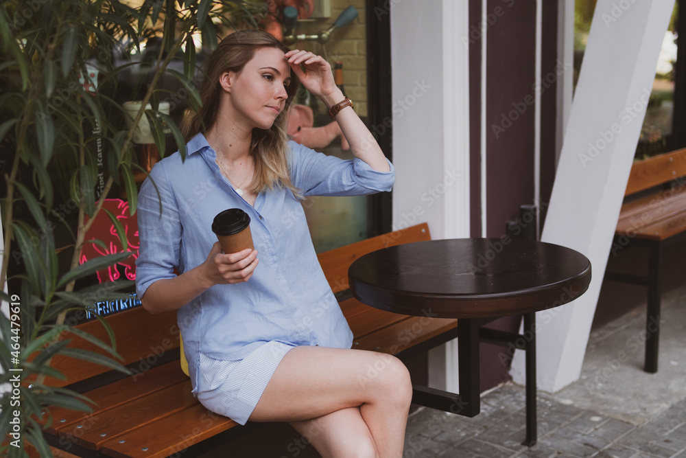 young blondy woman with coffee in a street cafe in summer young blondy woman with coffee in a street cafe in summer