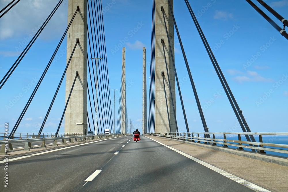 Fototapeta premium Motorrad bei Fahrt über Brücke mit Stahlseilen und Betonträgern auf Highway, Autobahn