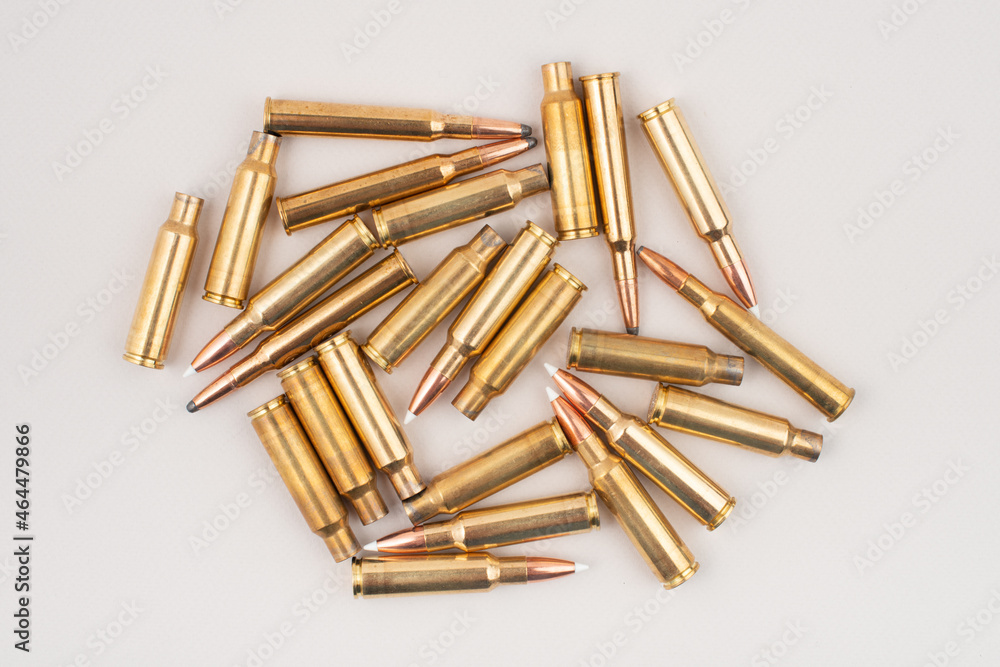Pile of rifle bullets isolated on grey background. Top view. Pile of rifle bullets isolated on grey background. Top view.