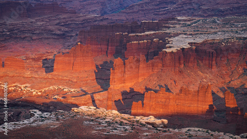 Dramatic towers and red sandstone cliffs cast purple shadows at sunset in abstract desert landscape. Canyonlands National Park, Utah, USA. © andrewhagen