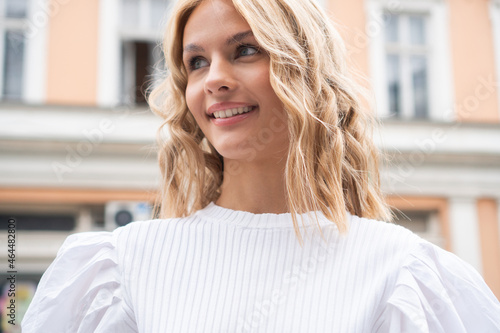 Free Download Portrait of a beautiful young woman with blond hair outside in the town. - GFXLoad