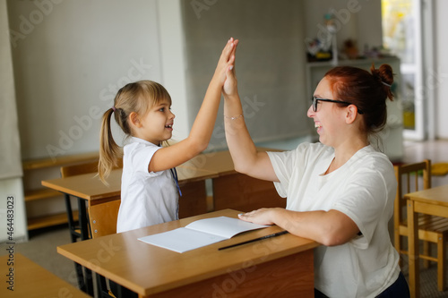 Canvas-taulu The teacher deals with the child with the girl, the teacher helps explain to the child in the classroom at the desk