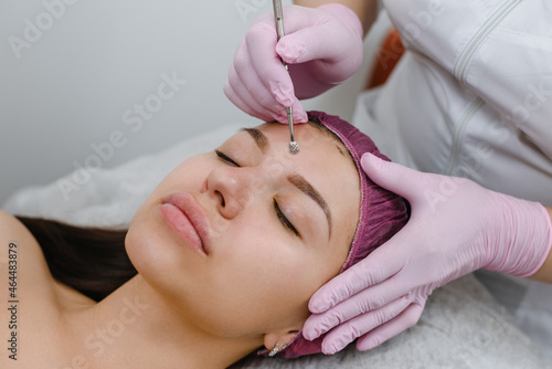 hygienic facial procedure to female client in modern beauty salon