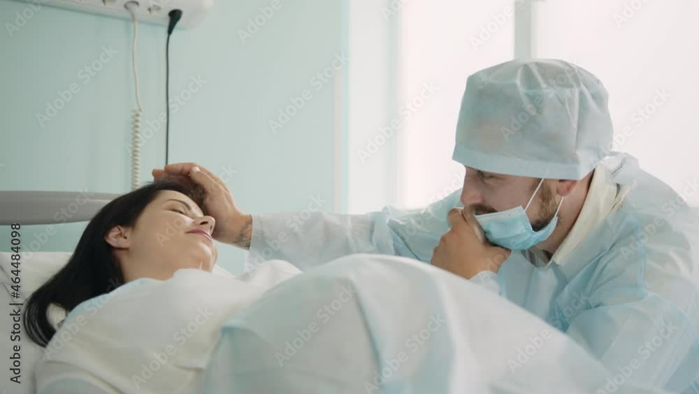 Female gynecologist examining health condition of pregnant woman during labour using medical equipment. Husband sitting near wife during childbirth process at clinic. Female gynecologist examining health condition of pregnant woman during labour using medical equipment. Husband sitting near wife during childbirth process at clinic.