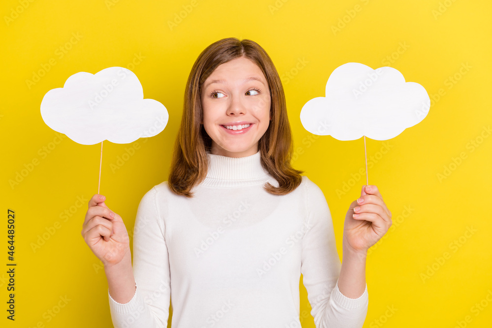 Photo of happy cheerful young small girl hold hands clouds sticks smile isolated on yellow color background Photo of happy cheerful young small girl hold hands clouds sticks smile isolated on yellow color background