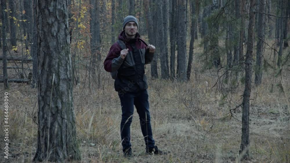 Traveler in the Pine Forest Looks Around and Enjoys Nature and a Beautiful Day. Young Man Hiking in Forest. Active healthy Beautiful man in wood. Man Walks Along Forest. Leisure, bio-tourism Traveler in the Pine Forest Looks Around and Enjoys Nature and a Beautiful Day. Young Man Hiking in Forest. Active healthy Beautiful man in wood. Man Walks Along Forest. Leisure, bio-tourism