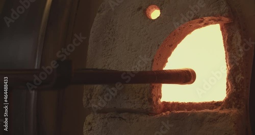 Professional glassblower working with the fire in the oven and the liquid glass