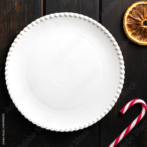 White plate on dark wooden background, copy space