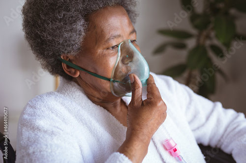 African american senior woman sitting on wheelchair with oxygen mask at home