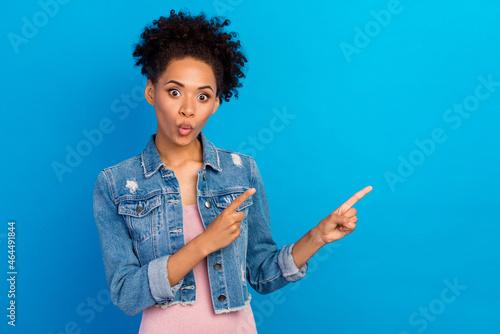 Photo of young funky afro american woman point finger empty space sale news isolated on blue color background