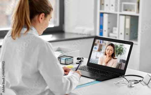 healthcare, technology and medicine concept - female doctor having video call with sick woman patient on laptop computer at hospital