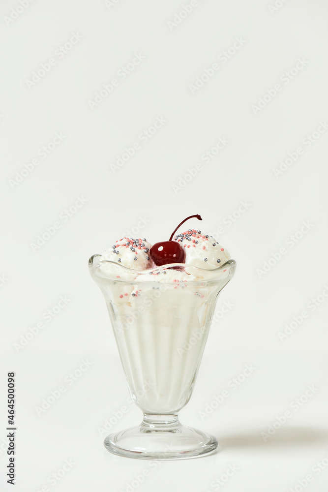 Vanilla sundae ice cream in cup with sweet grains and bing cherry on top isolated on white background Vanilla sundae ice cream in cup with sweet grains and bing cherry on top isolated on white background
