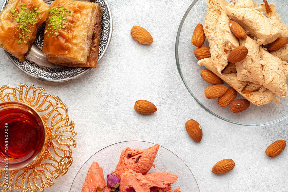 Assortment of Turkish delights with glass of tea on gray background Assortment of Turkish delights with glass of tea on gray background