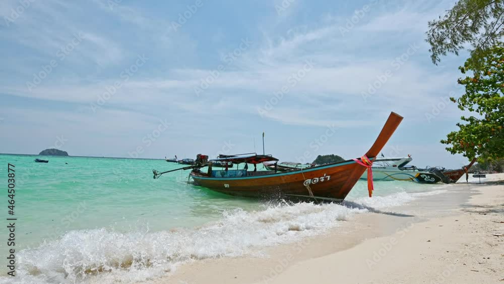 Beautiful tropical sea with wooden long-tail boat on the white beach at lipe island Beautiful tropical sea with wooden long-tail boat on the white beach at lipe island
