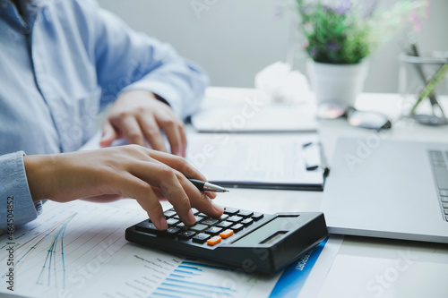 Close up of Man hand holding pen working on calculator to calculate business data. accountancy document, finance accounting concept