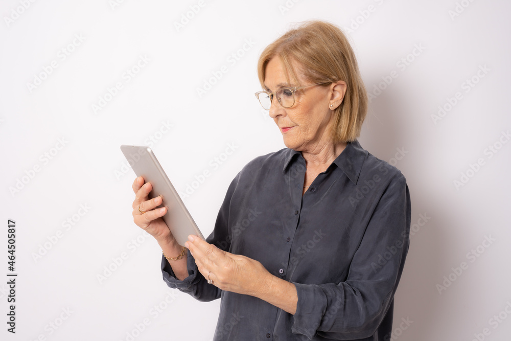 Happy senior woman using tablet computer isolated over white background. Happy senior woman using tablet computer isolated over white background.
