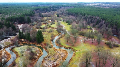 Fly over a winding river and green forest