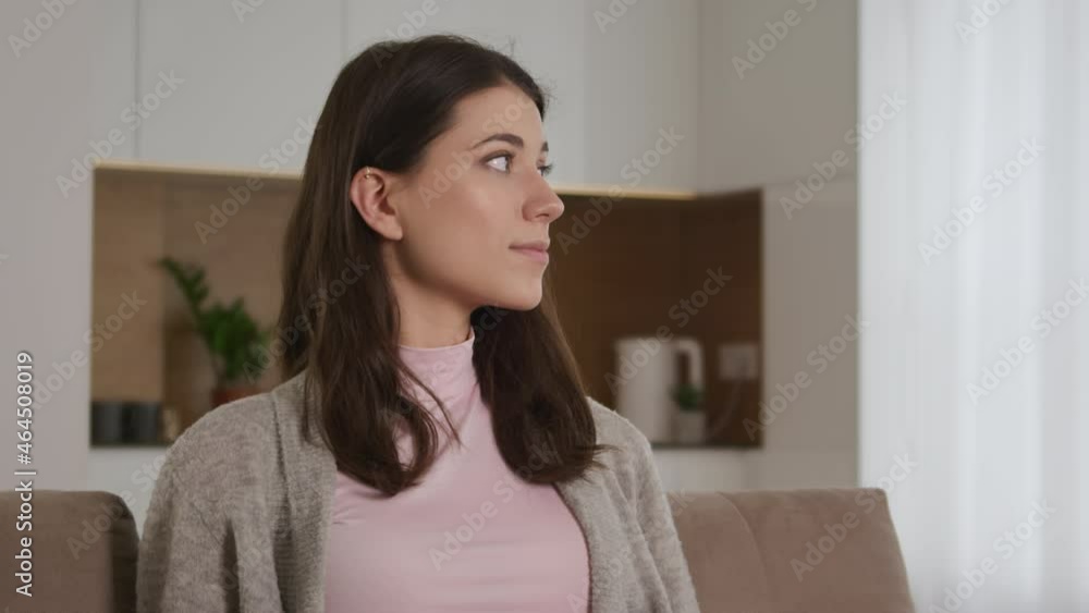 Portrait of a young caucasian woman looking sideways, turning to the camera and smiling while looking straight into the camera indoors Portrait of a young caucasian woman looking sideways, turning to the camera and smiling while looking straight into the camera indoors