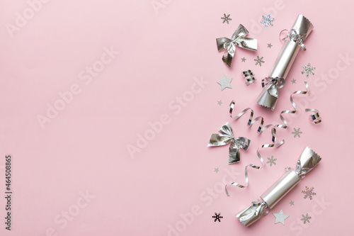 Vászonkép Christmas crackers with shiny confetti on color background, top view, copy space