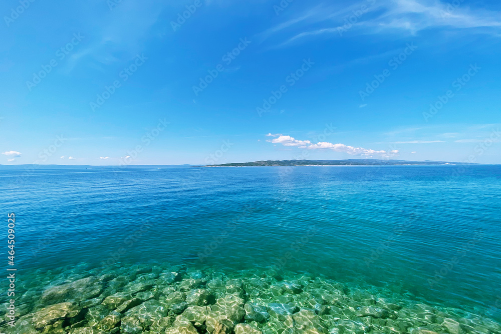 Fototapeta premium Summer vacation concept. Blue transparent sea water texture. Background of tranquil ocean water. Sea landscape with clear water.