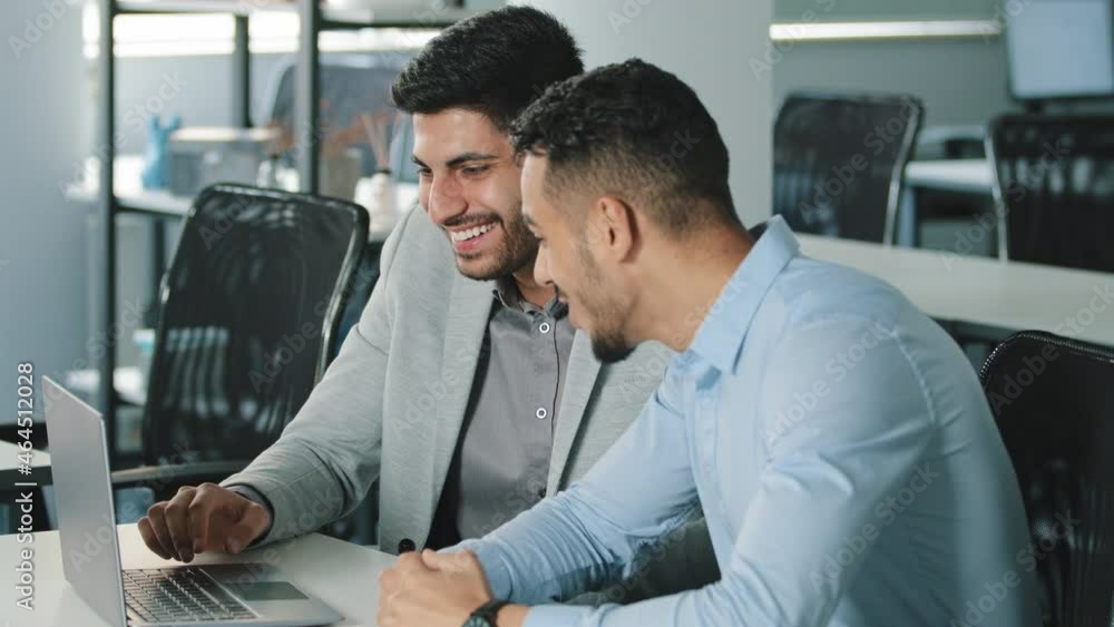 Two happy successful businessmen discussing company development strategy at brainstorming meeting in office. Smiling partners negotiating project rejoice excellent results together at workplace Two happy successful businessmen discussing company development strategy at brainstorming meeting in office. Smiling partners negotiating project rejoice excellent results together at workplace