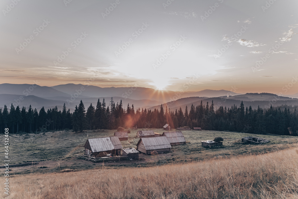 Naklejka premium mountain landscape with small houses and sunset