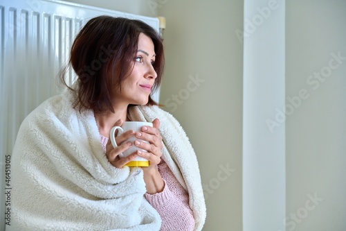 Cold winter autumn season at home  frozen woman near heating radiator