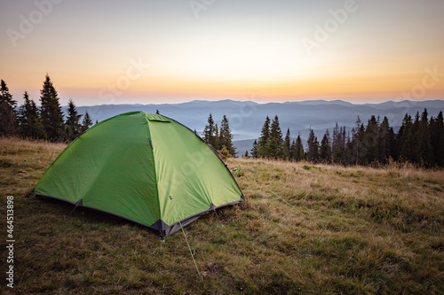 dawn in the mountains. mountain peak with tent and sunrise