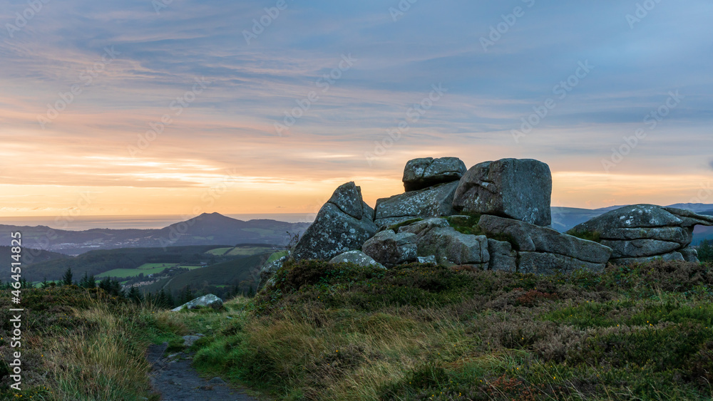 Sunrise over the southernmost tor on the summit of Three Rock mountain in Dublin, Ireland. Large granite rock formation landscape.