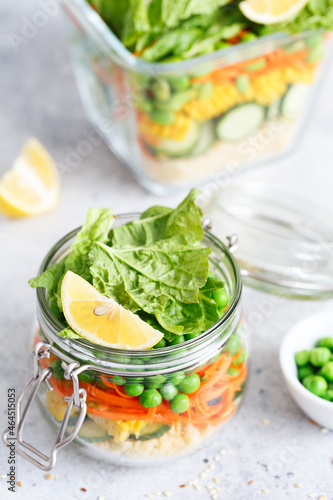Glass jar with fresh raw vegetables and couscous groats. Healthy Meal Prep - recipe preparation photos. Healthy vegan dishes in glass containers. Weight loss food concept. Salad in a jar.