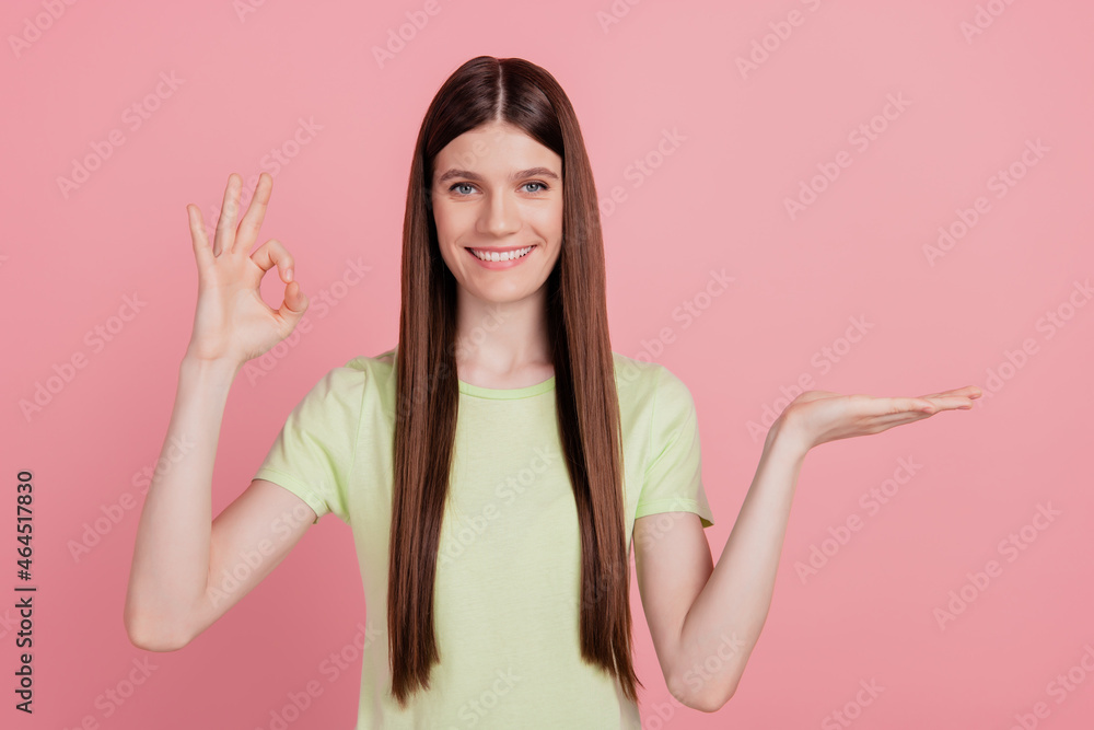 Photo portrait of girl happy positive smile demonstrate product offer suggest isolated on pastel pink color background Photo portrait of girl happy positive smile demonstrate product offer suggest isolated on pastel pink color background