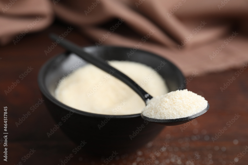 Gelatin powder in bowl and spoon on table, closeup Gelatin powder in bowl and spoon on table, closeup