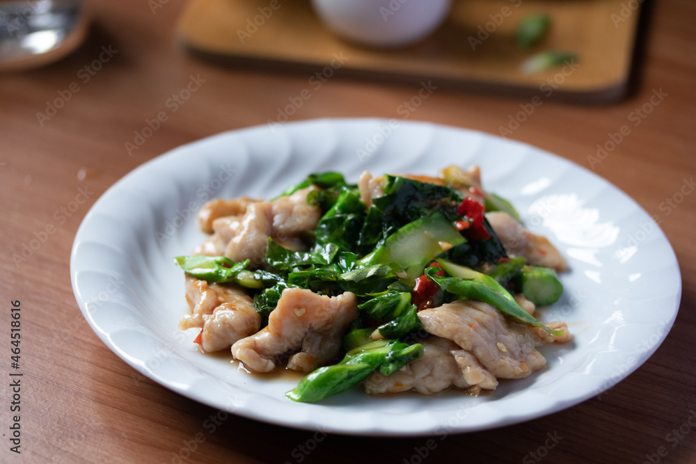 Stir-fried pork with kale and chilli in a white plate Stir-fried pork with kale and chilli in a white plate