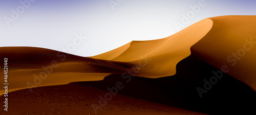 Yellow dark dunes and blue sky. Desert dunes landscape with contrast skies. Minimal abstract background. 3d rendering