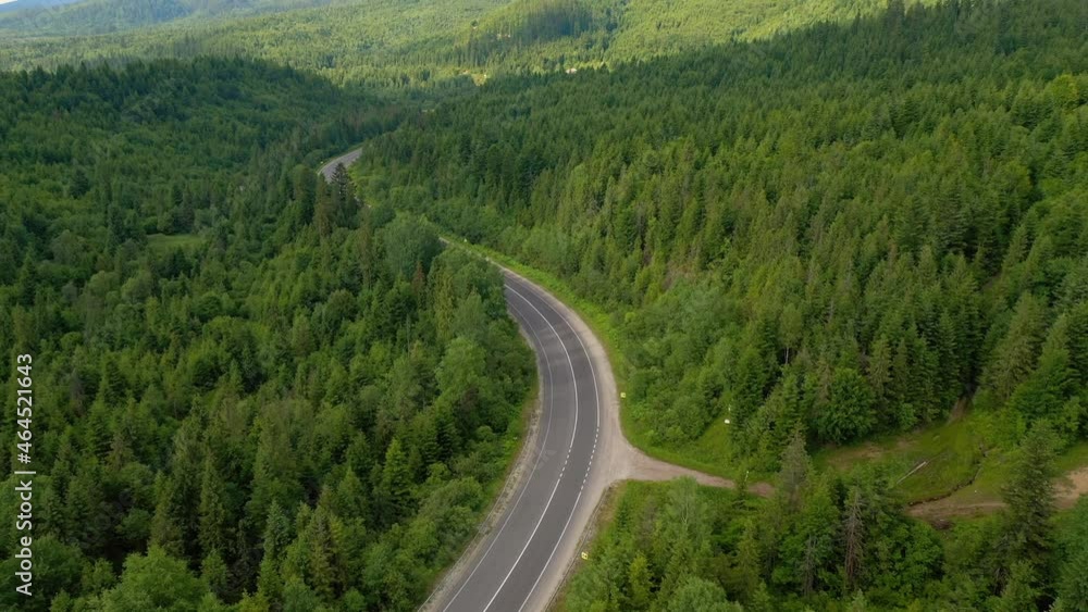Shooting of a winding road passing through the wood from a bird's eye view. Filmed 4k, drone video. Shooting of a winding road passing through the wood from a bird's eye view. Filmed 4k, drone video.