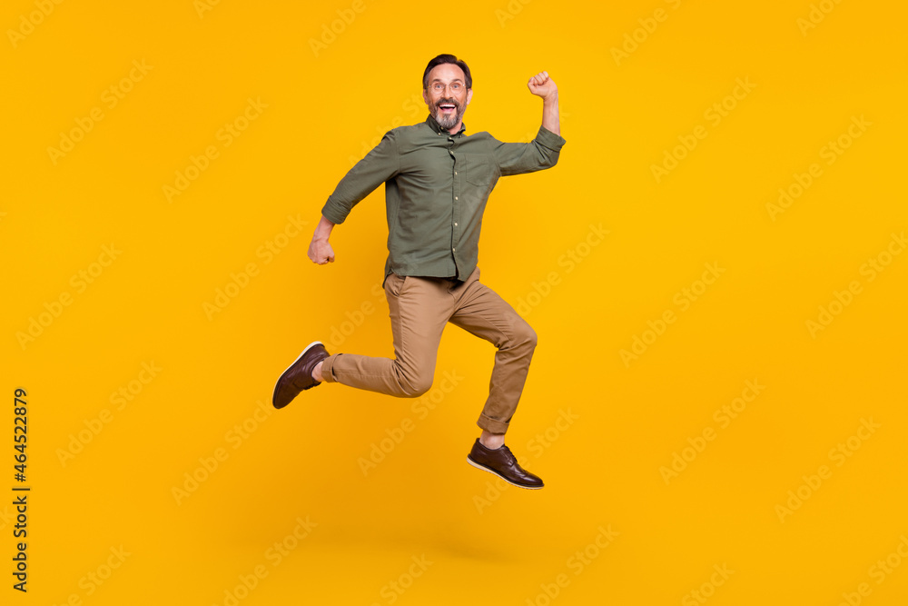 Full length body size view of attractive cheerful lucky man jumping rejoicing isolated over bright yellow color background