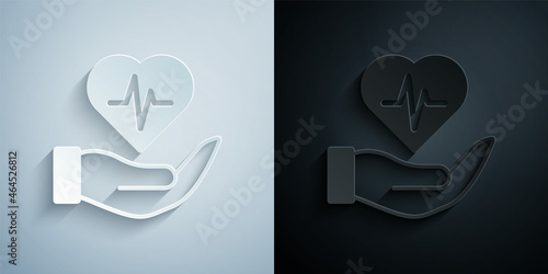 Paper cut Life insurance in hand icon isolated on grey and black background. Security, safety, protection, protect concept. Paper art style. Vector