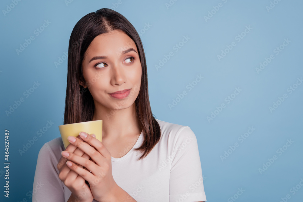 Portrait of adorable inspired dreamy lady hold cup look empty space on blue background Portrait of adorable inspired dreamy lady hold cup look empty space on blue background