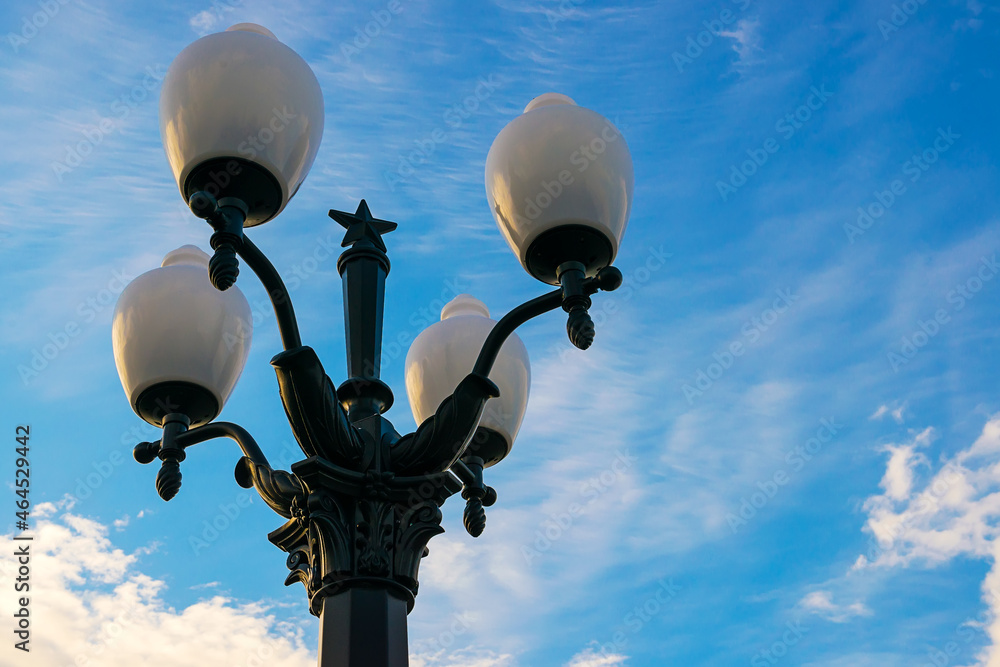 A lamppost against the sky with white clouds. A lamppost against the sky with white clouds.