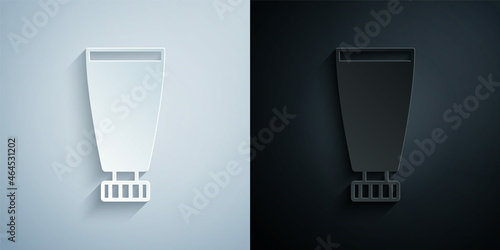 Paper cut Cream or lotion cosmetic tube icon isolated on grey and black background. Body care products for woman. Paper art style. Vector