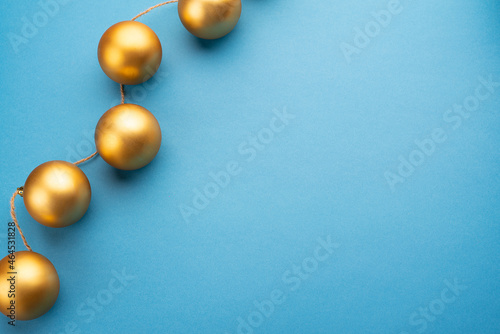 Gold Christmas balls on a light blue background. Top view. 