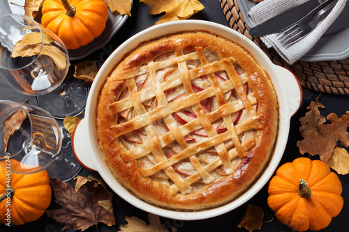 Delicious homemade apple pie and autumn decor on black table, flat lay. Thanksgiving Day celebration