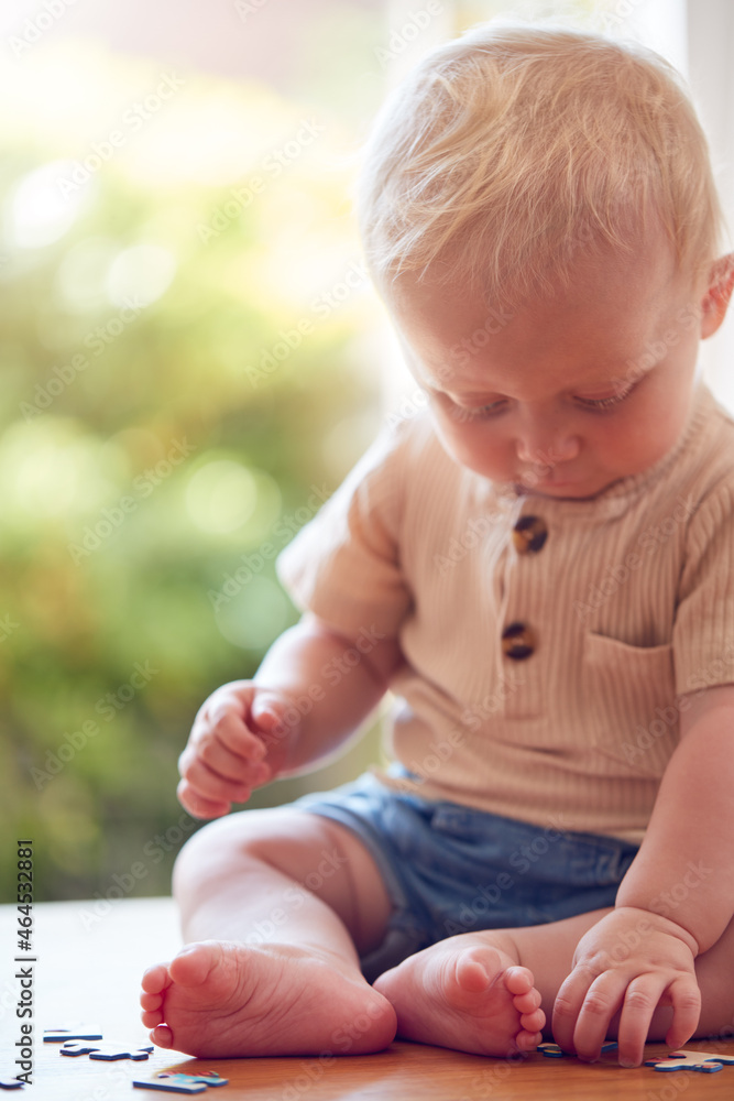 Baby Boy Having Fun Sitting At Home And Playing With Jigsaw Puzzle Pieces Baby Boy Having Fun Sitting At Home And Playing With Jigsaw Puzzle Pieces