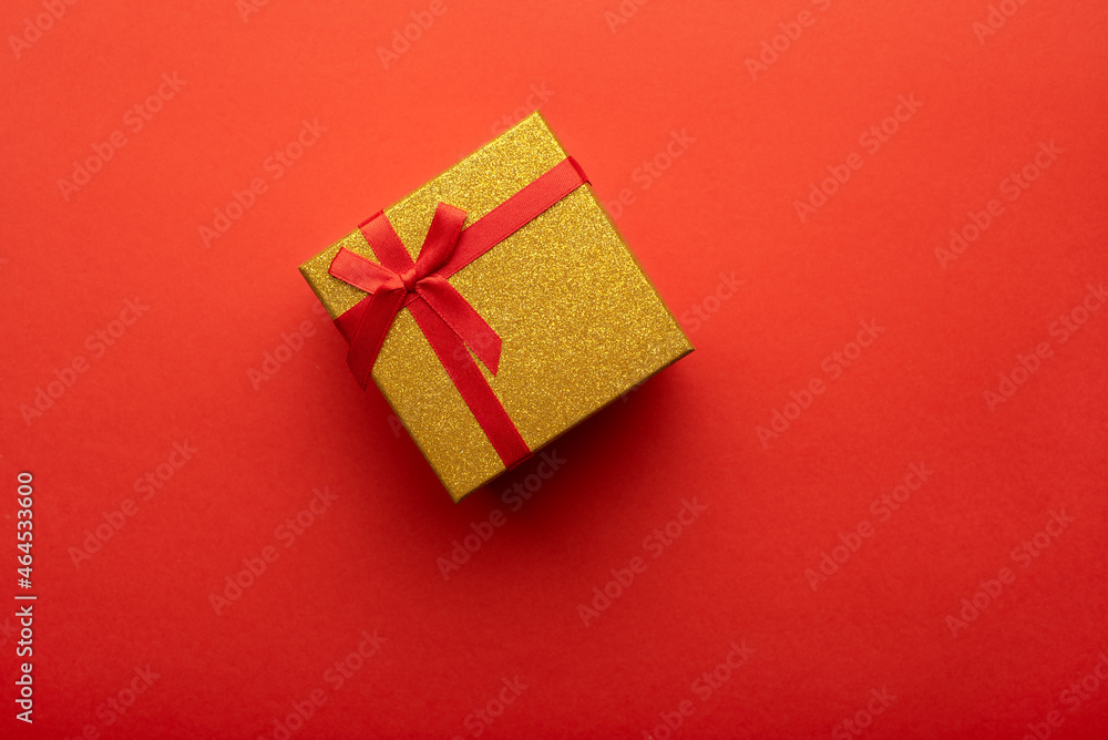 Red and gold gift box on a bright red background. Flat lay, top view.
Red and gold gift box on a bright red background. Flat lay, top view.